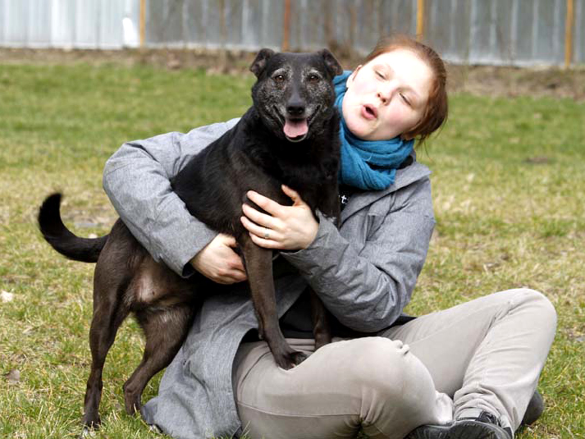 Schwarzer-hund-Kathy-mit-frau-auf-wiese Floras Auge ist nicht mehr zu retten